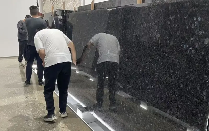 qc team inspecting blue granite slabs to ensure color consistency for commercial stone projects